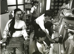 写真:パソコン教室で子供たちを教える、谷井亨さん。