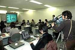 写真：セミナー初日、熱心に講義を受ける受講生を取材する報道カメラマン
